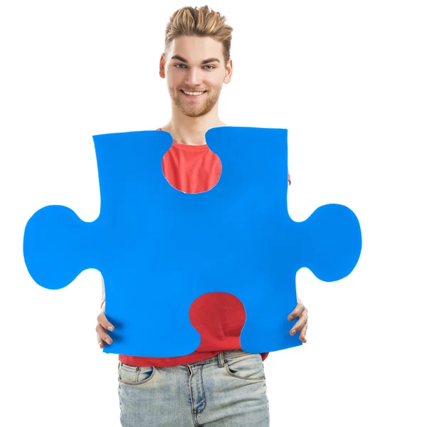 Joven sosteniendo una pieza del rompecabezas — Foto de Stock