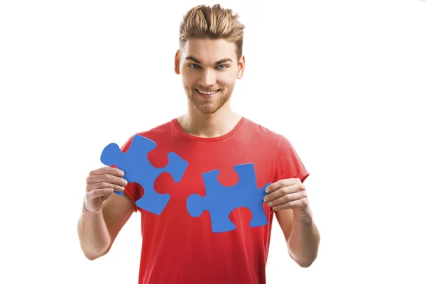 Jonge man houden puzzelstukjes — Stockfoto