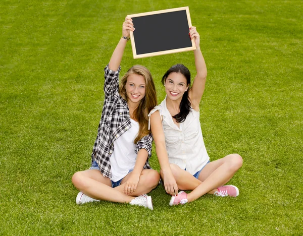 Estudantes felizes segurando um quadro — Fotografia de Stock
