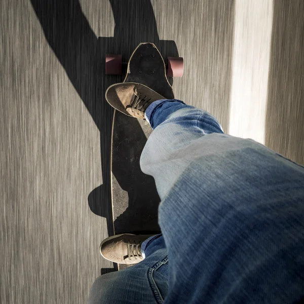 Uomo piedi cavalcando uno skateboard — Foto Stock