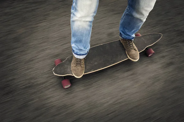 Uomo piedi cavalcando uno skateboard — Foto Stock