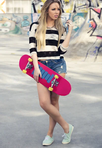 Девушка позирует со своим скейтбордом — стоковое фото