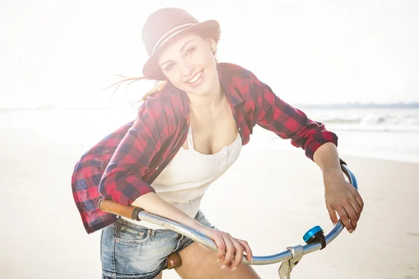女子骑着自行车在海滩上 — 图库照片