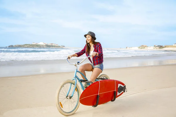 Surfer kobieta jazda rowerem na plaży — Zdjęcie stockowe