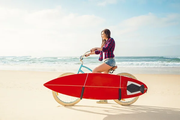 Surfer Mujer montar en bicicleta en la playa — Foto de Stock