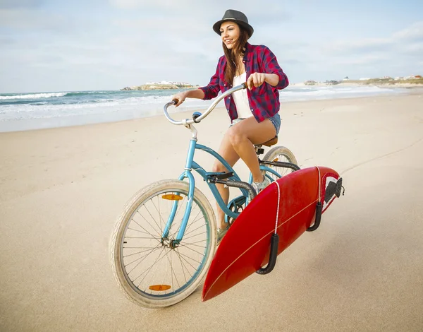 Surfista mulher andar de bicicleta na praia — Fotografia de Stock