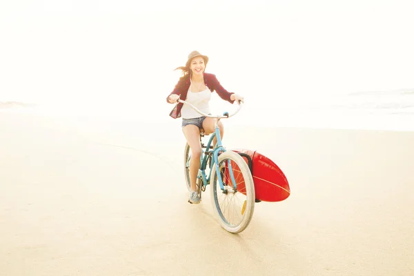 Surfista mulher andar de bicicleta na praia — Fotografia de Stock