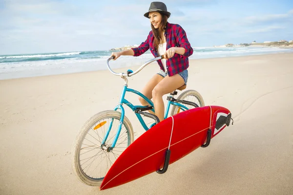 Surfer kobieta jazda rowerem na plaży — Zdjęcie stockowe