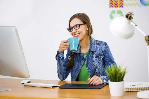 Женщина, работающая за столом в креативном офисе — стоковое фото
