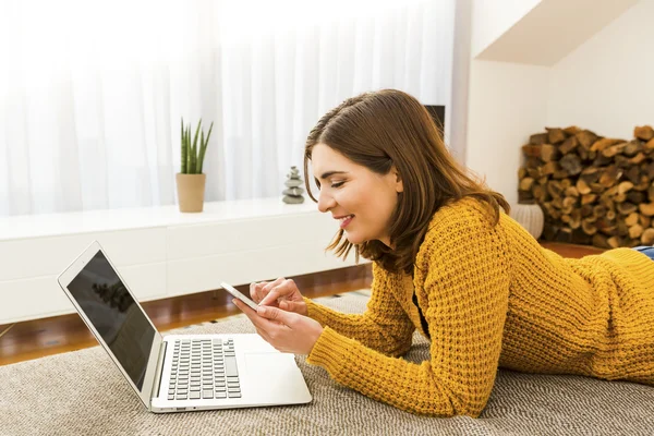 Mujer en casa trabajando con un ordenador portátil — Foto de Stock