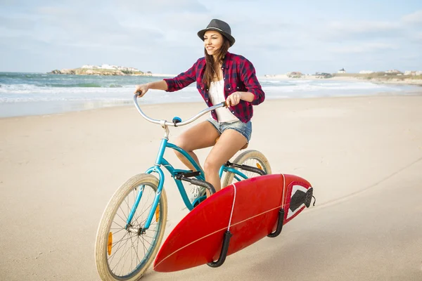 Mujer surfista montando bicicleta — Foto de Stock