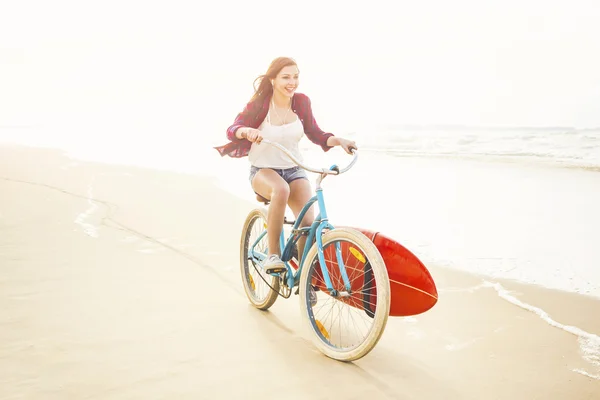 Mujer surfista montando bicicleta —  Fotos de Stock