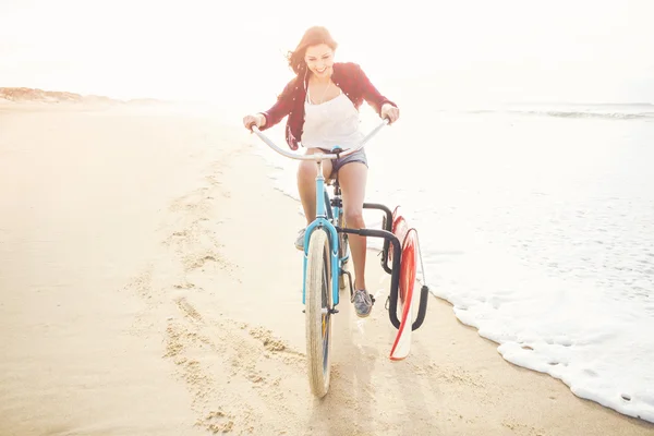 Surfer kvinna ridning cykel — Stockfoto