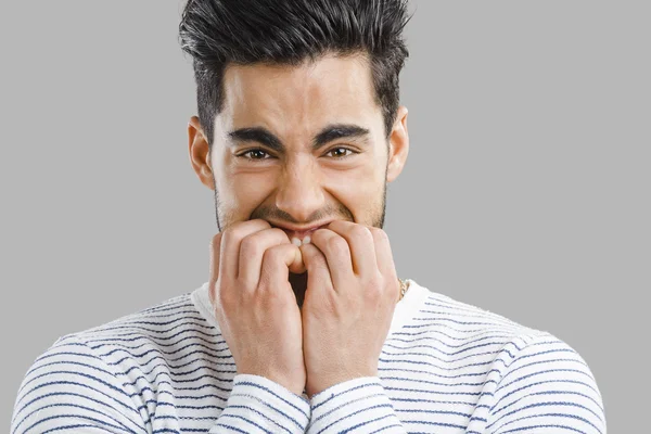 Worried young man biting nails — Stock Photo, Image