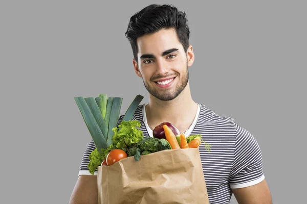 Homme portant un sac plein de légumes — Photo