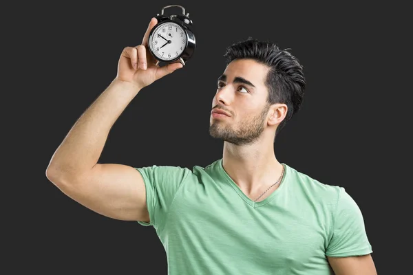 Joven sosteniendo un reloj — Foto de Stock