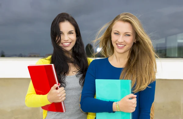 Estudantes adolescentes segurando mochilas e sorrindo — Fotografia de Stock