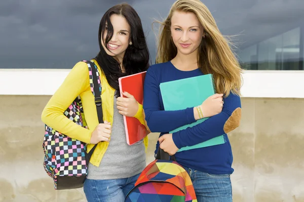 Estudantes adolescentes segurando mochilas e sorrindo — Fotografia de Stock