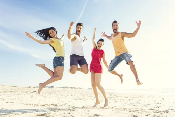 Friends making a jump together at the beach — Stock Photo, Image