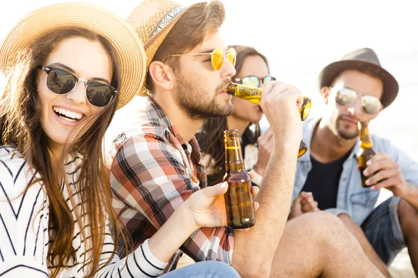 Vänner dricka en kall öl på stranden — Stockfoto