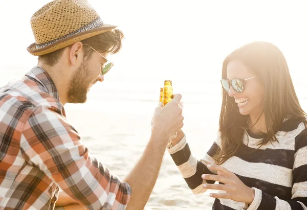 Fiatal pár sört a strandon — Stock Fotó