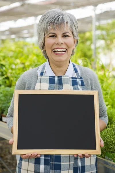 Elderly woman in a green house — Stock Photo, Image