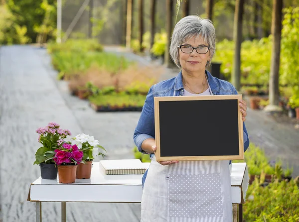 Ältere Frau in einem Gewächshaus — Stockfoto