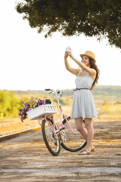 Mujer con su bicicleta y haciendo una selfie —  Fotos de Stock