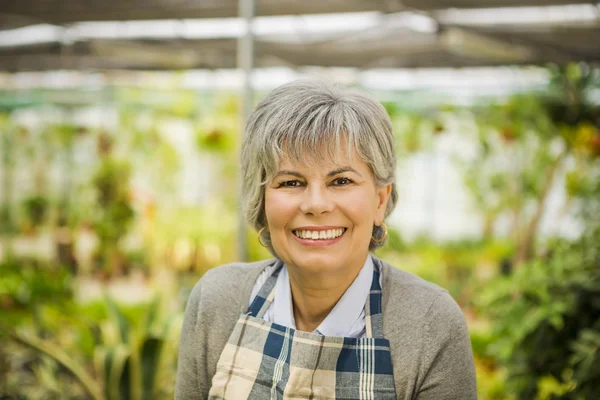 Mujer jardinería y mirando a Camer — Foto de Stock