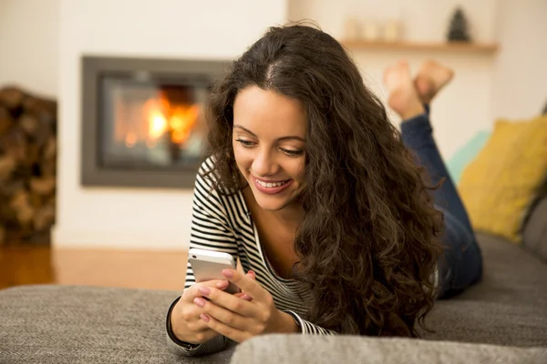 Kobieta z jej telefon w domu — Zdjęcie stockowe