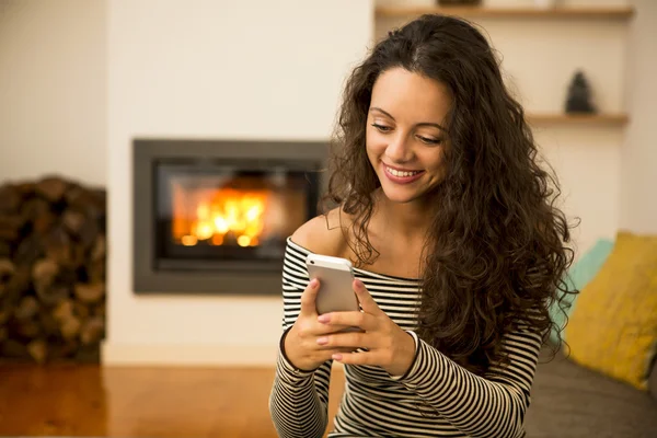 Woman with her cellphone at home — Stock Photo, Image