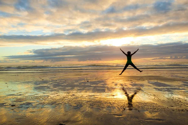 Mulher pulando ao pôr do sol — Fotografia de Stock