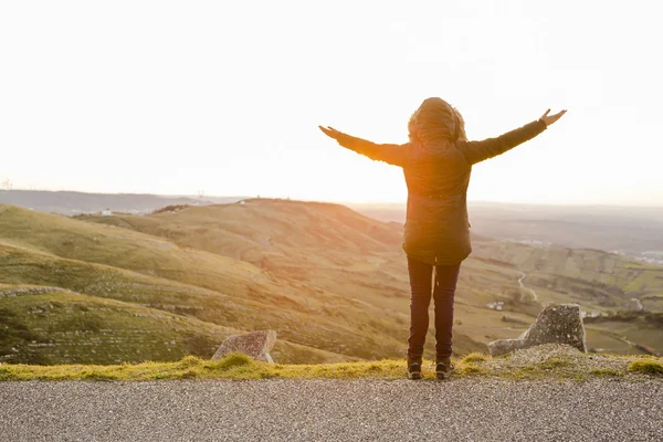 Vrouw met open armen bij de zonsondergang — Stockfoto