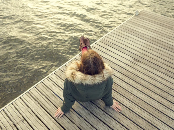 Mulher sentada perto de um lago — Fotografia de Stock