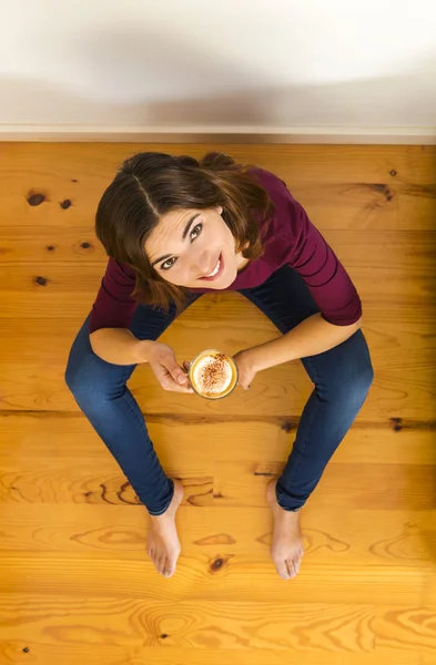 Женщина дома пьет капучино — стоковое фото