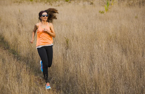 Femme attrayante courant sur une prairie — Photo