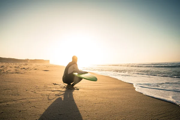 Серфер з дошкою для серфінгу і спостереження за хвилями — стокове фото