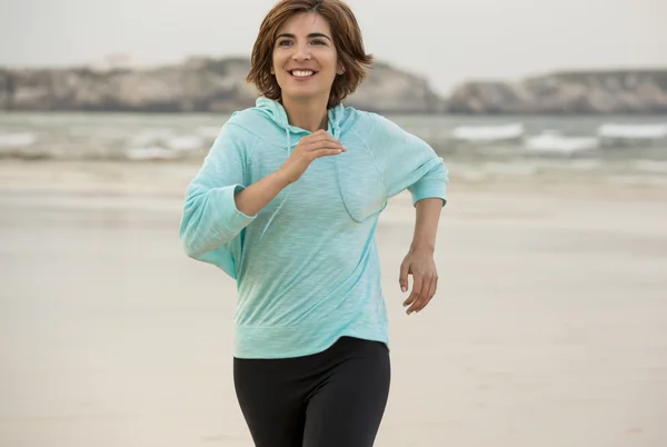 Frau läuft am Strand — Stockfoto