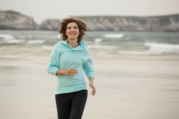 Frau läuft am Strand — Stockfoto