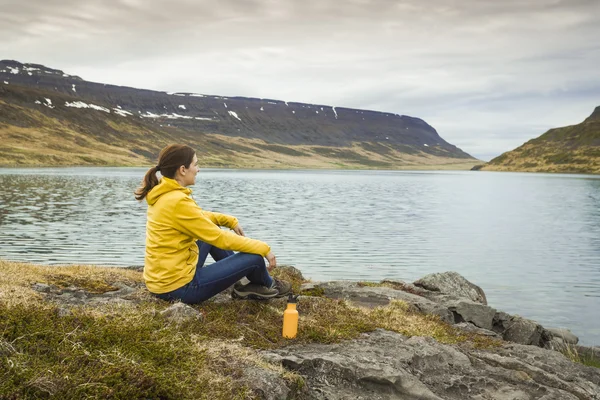 Vrouw rust dicht bij een prachtig meer — Stockfoto