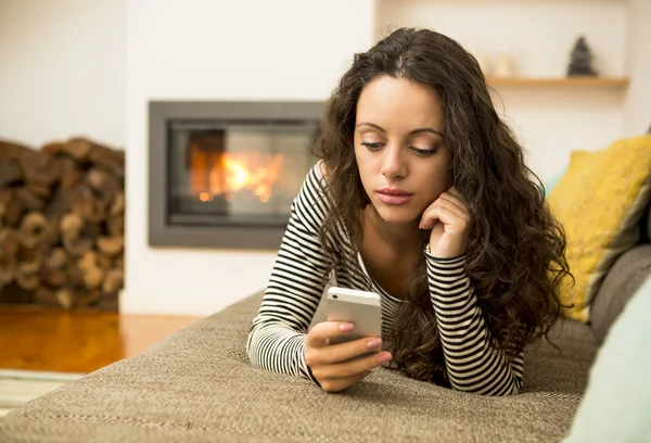 Mujer con su celular en casa — Foto de Stock