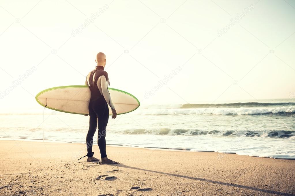 Surfer with surfboard and watching the waves