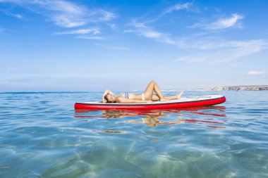 Kadın kürek sörf tahtası üzerinde rahatlatıcı