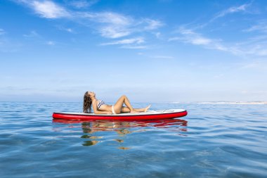 Kadın kürek sörf tahtası üzerinde rahatlatıcı