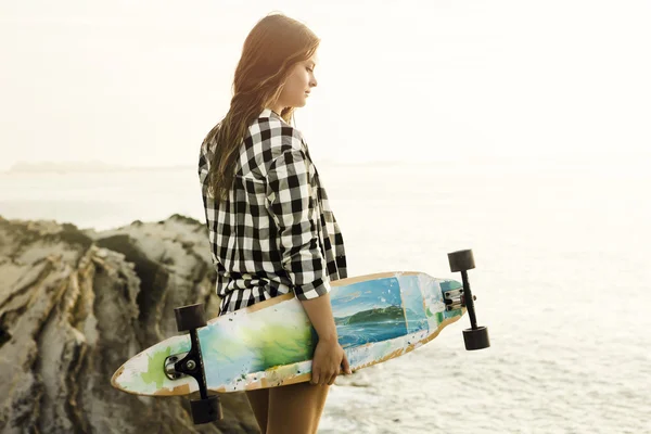 Junge Frau posiert mit Skateboard — Stockfoto