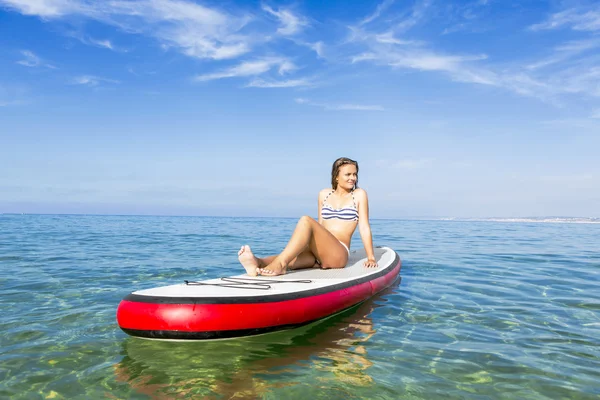 Mulher sentada sobre uma prancha de surf — Fotografia de Stock