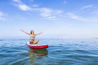 Kadın kürek sörf tahtası üzerinde rahatlatıcı