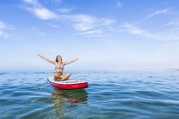 Mujer relajándose sobre una tabla de surf de paddle —  Fotos de Stock