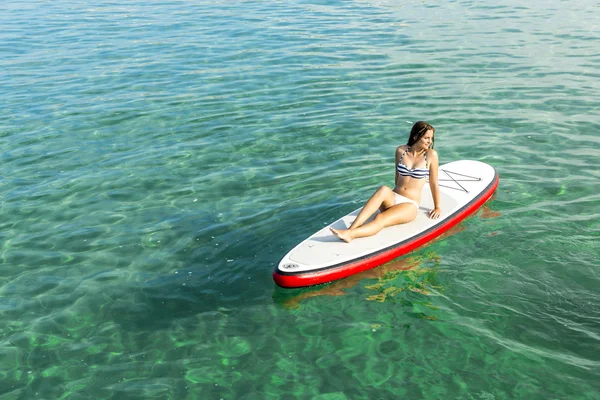 Mujer relajándose sobre una tabla de surf de paddle —  Fotos de Stock