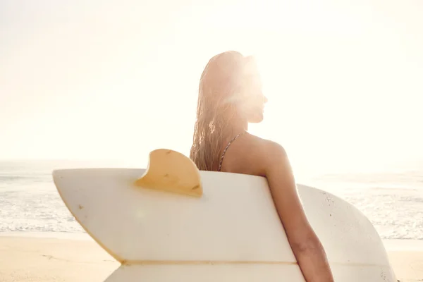 Vrouw met surfboard na een dag van branding — Stockfoto